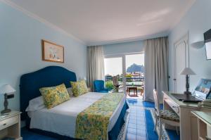una camera d'albergo con letto, scrivania e finestra di Punta Molino Beach Resort & Thermal Spa a Ischia