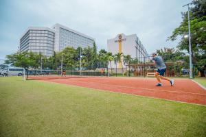 a man is playing tennis on a tennis court at Accra City Hotel in Accra