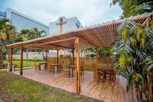 a wooden pergola with tables and chairs on a wooden deck at Accra City Hotel in Accra