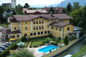 a large yellow house with a swimming pool at Hotel Gasthof Kamml in Wals