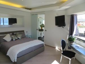 Schlafzimmer mit einem Bett, einem Schreibtisch und einem TV in der Unterkunft Ficano's Dream in San Siro