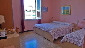 a hotel room with two beds and a window at Bed and Breakfast Gioiello in Celle Ligure