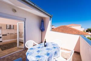 eine Terrasse mit Tisch und Stühlen auf einem Balkon in der Unterkunft Apartman Anamarija in Trogir