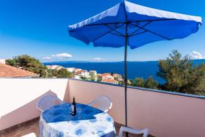 einen blauen Tisch mit Sonnenschirm auf dem Balkon in der Unterkunft Apartman Anamarija in Trogir