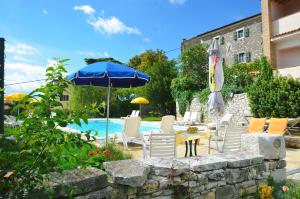 a patio with a table and chairs and an umbrella at Villa Visnjan Residence 2 in Višnjan