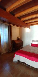 a bedroom with a bed with a red and white blanket at A Teppa in Luri