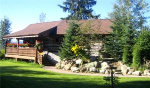 a cabin with a bunch of rocks in front of it at Nakiska Bear Ranch in Clearwater