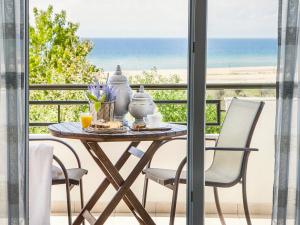 a table and chairs on a balcony with a view of the ocean at Akti Retzika in Epanomi