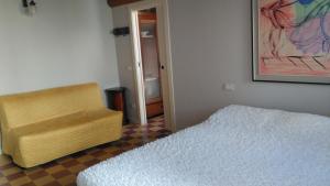 a bedroom with a bed and a chair and a painting at B&B Casa Lulù in Brembate