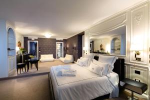 a bedroom with a white bed and a living room at Relais La Speranzina in Sirmione