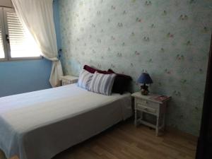バレンシアにあるApartamentoのベッドルーム1室(ベッド1台、ランプ付きテーブル付)