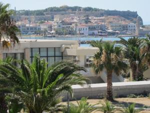 un edificio con palmeras frente a una ciudad en The Sea View Apartments, en Rethymno