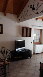 sala de estar con TV de pantalla plana en la pared en Casa vacanze Ca' Manara, en Stazzona