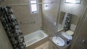 La salle de bains est pourvue d'une baignoire, d'un lavabo et d'un miroir. dans l'établissement Estancia Río Abajo, à Trevelín