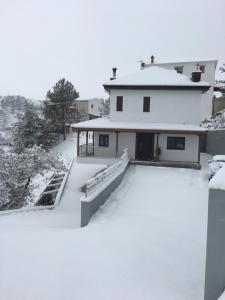 a house with snow on the roof at Kyperounta Apartment in Kyperounda