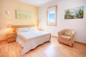 a bedroom with a bed and a chair in it at Edificio Prieto VIV 2E in Puerto del Rosario +19 photos