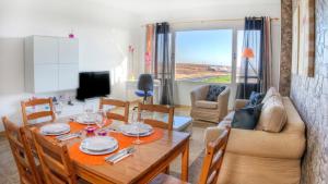 a dining room and living room with a table and a couch at Edificio Prieto VIV 2E in Puerto del Rosario