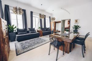 a living room with a wooden table and black chairs at Feel Ljubljana Centre in Ljubljana
