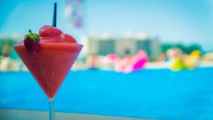 
a red and white drink sitting on top of a beach at Sol House The Studio - Calviá Beach in Magaluf
