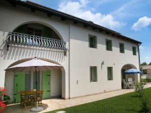 een wit gebouw met een tafel en een paraplu bij B&B Le Olme in Mogliano Veneto