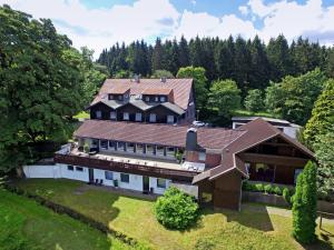 eine Luftansicht eines großen Hauses mit Bäumen in der Unterkunft Hotel Mein Bergblick in Hahnenklee-Bockswiese