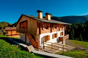 una casa in cima a una collina con alberi di Albergo Diffuso Sauris in Lateis a Lateis