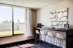 a bar with stools in a room with a window at Hotel des Congrès in Villeurbanne