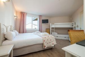 una camera con un letto e un letto a castello di L'Ermitage Hotel & Restaurant a Saulges