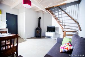 a living room with a couch and a wood stove at Domek na Leśnej in Pogorzelica