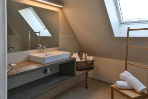 een badkamer met een wastafel en een spiegel bij Gites La Maison Mann in Sand +31 foto's