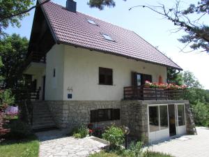 una casa con una pared de piedra y un techo en Guest House Nenad, en Lagos de Plitvice