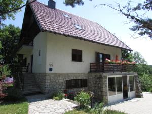 a house with a stone wall and a roof at Guest House Nenad in Plitvička Jezera