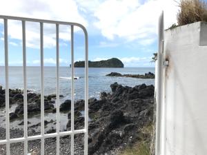 a gate to the beach with the ocean in the background at A Villa by the Sea Bed & Breakfast in Vila Franca do Campo