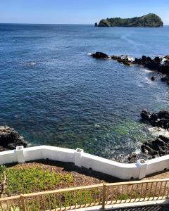 a bath tub sitting next to a body of water at A Villa by the Sea Bed & Breakfast in Vila Franca do Campo