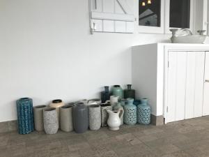 a bunch of vases are lined up against a wall at A Villa by the Sea Bed & Breakfast in Vila Franca do Campo