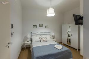 biała sypialnia z łóżkiem i telewizorem w obiekcie B&B A Casa dei Nonni w mieście Enna