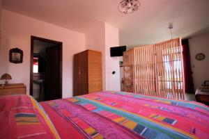 una camera da letto con un copriletto colorato di Tenuta Fontò a Gallipoli