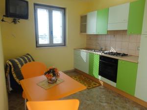 a kitchen with green cabinets and a table and chairs at Villettemire in Capo Vaticano