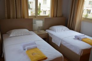 - 2 lits dans une chambre d'hôtel avec des serviettes dans l'établissement Anthorina Villa 7, à Protaras