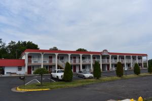 a large building with cars parked in a parking lot at Red Carpet Inn & Suites Culpeper in Culpeper