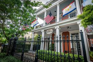 un edificio con banderas americanas encima en Rathbone Mansions New Orleans en Nueva Orleans