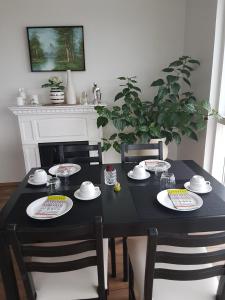 a black table with four chairs and a black table with plates at Hafdals Hotel in Akureyri