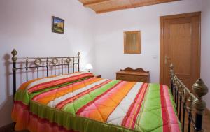 a bedroom with a bed with a colorful blanket at Casa Rural El Fronton in Vadillo