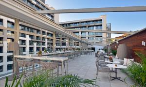 an outdoor patio with tables and chairs on a building at INNSiDE by Meliá Palma Bosque in Palma de Mallorca