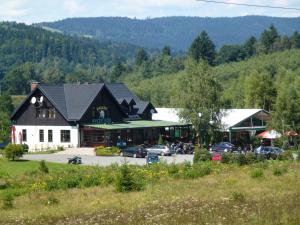 a large building with cars parked in a parking lot at Zajazd Byczy Róg in Międzylesie