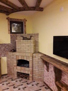a living room with a brick fireplace with a flat screen tv at Arthur Rest House in Dilijan