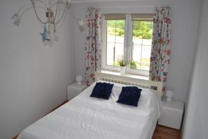 a white bed in a room with a window at Dom u Ewy Bory Tucholskie in Śliwice