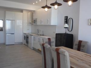 a kitchen with a table and a sink and a refrigerator at Apartments Easy La Nogalera in Torremolinos