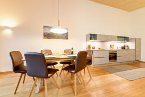 uma cozinha e sala de jantar com mesa e cadeiras em Gastler Chalet em Riezlern