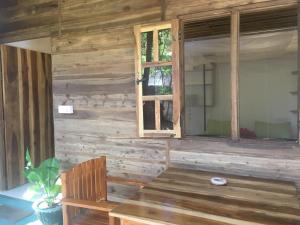 Habitación de madera con mesa y ventana en Garden Cottage Arugambay en Arugam Bay